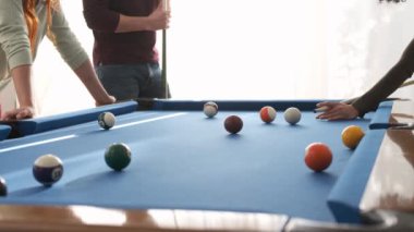 Hafta sonu evde oyun masasında arkadaşlarıyla bilardo oynayan isimsiz bir kadın.