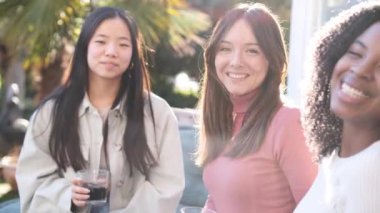 Neşeli çeşitli kadın arkadaşlar, günlük giysiler içinde. Güneşli bir yaz gününde hafta sonu partisinde arka bahçede içeceklerin keyfini çıkarıyorlar.