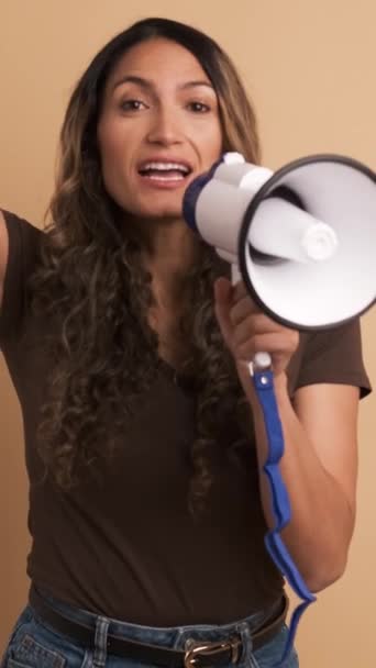 一个有着棕色背景的视频 一个女人用扩音器快乐地大喊 纵向图像 — 图库视频影像