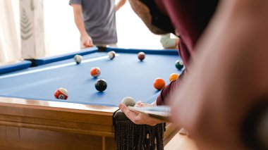 Hafta sonu evde arkadaşlarıyla bilardo oynayan isimsiz bir adam.