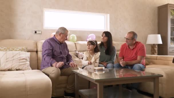 誕生日ケーキを食べてソファーに座っている幸せな家族のビデオ — ストック動画