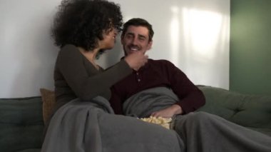 Keyifli çeşitli genç çiftler kanepede patlamış mısır fırlatırken aynı zamanda komedi filminin tadını çıkarıyorlar. Hafta sonu evde gülüyorlar.