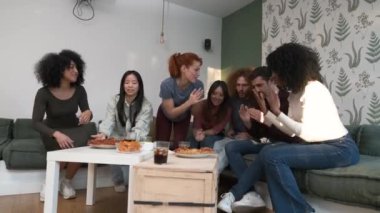 Heyecanlı erkek ve kadın arkadaşlardan oluşan çeşitli bir grup hafta sonu boyunca oturma odasında lezzetli pizzalardan zevk alırken neşeleniyorlar. Evde toplanıyorlar.