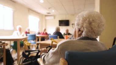 Yaşlılar evlerinin aydınlık odasındaki masalarda oturan yaşlıları yavaş çekimde büyüt