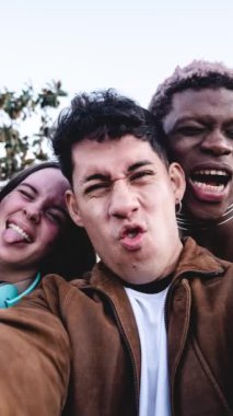 Stop motion group of cheerful multiracial students making faces and taking selfie after university studies