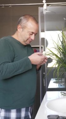 Evde uyandıktan sonra dişlerini ve yüzünü temizleyen gay bir adamın videosu.