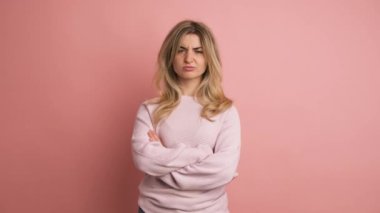 Stüdyo videosu ağır çekimde pembe arka planda sarışın yetişkin bir kadının kafasıyla olumsuzluğu ifade etmesi.