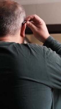 Banyodaki aynanın karşısına doğru dürüst işitemeyen bir adamın dikiz aynasının videosu.