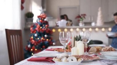Evde bir çocuk sofrayı kurarken Noel süsleri üzerine odaklanmış yavaş çekim videosu.