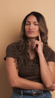 Düşünceli, Latin bir kadının kahverengi geçmişine sahip bir video, karardan emin değil. Dikey Görüntü