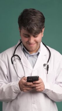 Stüdyoda sağlık araştırmaları, tıbbi uygulamalar ve internet danışmanlığı için akıllı telefonlu gülümseme ve doktor.