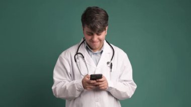 Stüdyoda sağlık araştırmaları, tıbbi uygulamalar ve internet danışmanlığı için akıllı telefonlu gülümseme ve doktor.