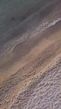 Genç adam kıyıda tek başına koşuyor. Üst görünüm, Hava görünümü