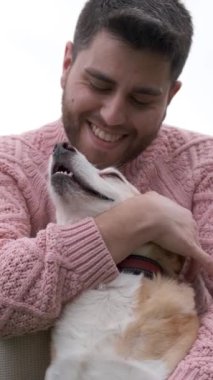 Adam parkta günün tadını çıkarırken köpeğine sarılıp okşuyor. Evcil hayvan ve köpek konsepti.