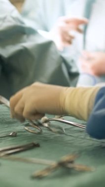Cerrahi üniformalı ve eldivenli bir grup isimsiz cerrah ameliyathanede yüzsüz hemşirenin altında doktorlara makas verirken...