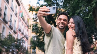 Gündüz vakti kız arkadaşıyla resim çektiren İspanyol asıllı mutlu bir adamdan.