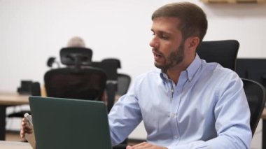 İşadamı, iletişim ve analizi birlikte dengelediği sırada dizüstü bilgisayar ve akıllı telefonla birden fazla iş yaparken proje hakkında tartışmaya başlıyor.