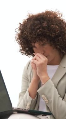 Kıvırcık saçlı iş kadını dizüstü bilgisayarı üzerinde çalışırken stres ve endişe yaşıyor. Dikey görüntüler