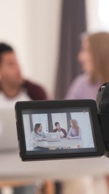 Kayıt, üç iş arkadaşıyla stratejileri tartışan ve bir ofis ortamında işbirliği yapan bir iş toplantısını kaydediyor.