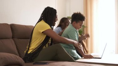 Başarılı çocuk, annesinin ve kız kardeşinin yanında sevinçle kutluyor. Evde dizüstü bilgisayarın başında toplanıp gülüşlerini ve heyecanlarını paylaşıyorlar. Başarı ve beraberliğin yürek ısıtan anlarında.