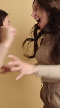 İki kadın neşeli bir anı paylaşıyor, neşeli ve neşeli bir atmosferde birlikte gülüyor ve kutluyor, arkadaşlığı ve mutluluğu iletiyor.