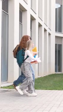 Öğrenciler okul binalarının dışındaki kağıtları havaya fırlatıp okul yılının bitmesini kutluyorlar. Dikey görüntüler