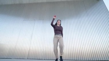 Yetenekli dansçı, dinamik koreografi yoluyla yaratıcılığını ve tutkusunu ifade ederek modern metalik bir zemine karşı enerjik hareketler sergiliyor.