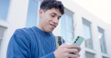 Üniversite öğrencisi cep telefonu uygulaması kullanıyor, sosyal medyadan keyif alıyor, mesajlaşıyor ya da dışarıda oyun oynuyor.