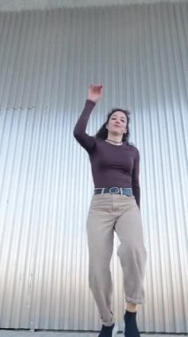 Tutkulu kadın dansçı endüstriyel metal arka planına karşı ritim ve yaratıcı enerjiyle dinamik şehir dansı hareketleri yapıyor.