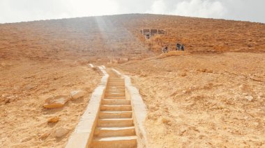 Turistler yıldız ışığı altında Mısır 'daki eğimli hapşırık piramidinin basamaklarını tırmanıyor.
