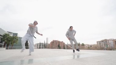 Yetenekli break dansçılar dinamik break dansçılar, canlı şehir meydanında akrobatik figürleri mükemmelleştiriyorlar, şehir dans kültürünü ve gençlik enerjisini sergiliyorlar.