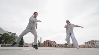 Şehir sokaklarında güçlü akrobatik hareketler yapan dinamik break dansçılar, yüksek enerjili sokak dansı performansları sergiliyorlar sanatsal beceri ve fiziksel hünerlerini şehrin arka planına karşı harmanlıyorlar.