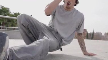 Genç break dansçı dinamik hareketler sergiliyor ve kendini dansla ifade ediyor.