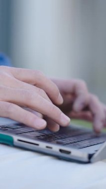 Erkek ellerinin dizüstü bilgisayarda yazı yazarken, kod yazarken ya da bir proje üzerinde çalışırken yakın plan çekimleri. Dikey görüntüler