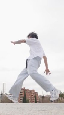 Genç break dansçı dinamik akrobatik hareketleri ve imza donmalarını mükemmelleştiriyor. Şehir parkında enerji ve tutku ile sokak dansı becerilerini gösteriyor.