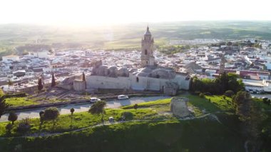 Altın güneş ışığı, İspanya 'nın Endülüs şehrinde tarihi bir kilise ve büyüleyici bir kasaba olan Medine Sidonia' yı yıkıyor.