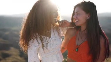 İki mutlu çok ırklı genç kadın gün batımında güzel bir çöl kanyonunda suç ortaklığı ve kahkahaların tadını çıkarıyor.