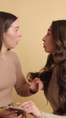 İki arkadaş, akıllı telefondan gelen beklenmedik haberlere tepki göstererek neşe içinde kahkahalarla gülmeye başlarlar.