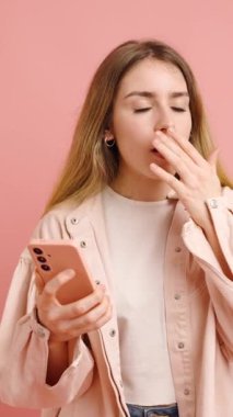 Stüdyoda, akıllı telefonuyla iletişim kurarken, meraktan şaşkınlığa ve neşeye kadar çeşitli duygular yaşayan genç bir kadının görüntüsü.