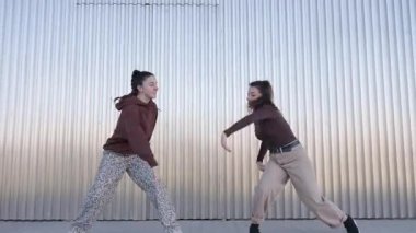 Yetenekli kadın dansçı, endüstriyel metal duvarlara karşı etkileyici hareketler sergiliyor ve dinamik hip hop koreografisi yapıyor.