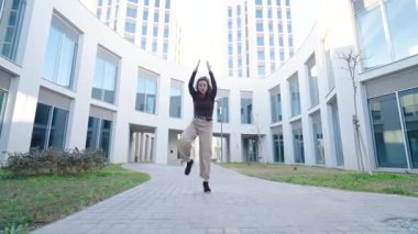 Enerjik kadın dansçı dinamik çağdaş koreografi sergiliyor, şehir ortamında tutkulu bir hareketle özgürlüğü ifade ediyor.