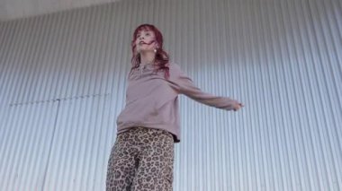 Modern dansçı, akışkan, endüstriyel metal duvara karşı anlamlı bir hareket, dinamik enerji ve kentsel performans sanatının sanatsal tutkusunu sergiliyor.