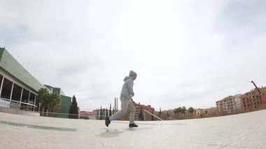 Yetenekli break dansçı dinamik akrobatik hareketler yapıyor, güçlü akışkan hareketlerle şehir manzarasında yüksek enerjili sokak dansı teknikleri uyguluyor.