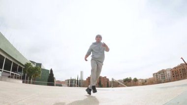 Yetenekli break dansçı, şehir ortamında yeteneklerini ve çevikliğini sergileyerek dinamik bir takla atar.