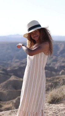 Canlı turistler dağ zirvesinde özgürce dans ediyor, neşe saçıyor ve güneşli yaz maceraları boyunca vahşi doğayı kucaklıyor.