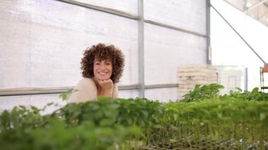 Kendini adamış sera işçisi, genç fideleri dikkatle inceliyor, sürdürülebilir tarım sürecinde bitki sağlığını profesyonel bakım ve gerçek gurur ile izliyor