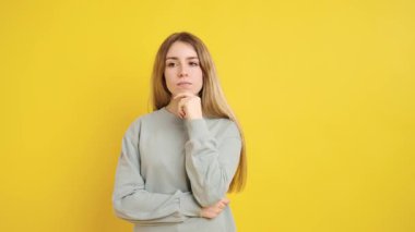 Stüdyoda genç bir kadının parlak sarı bir arka planda kendini izole edip bir fikri olduğunu gösteren fotoğraflar.