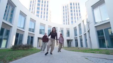 Modern şehir mimarisi ortamında dinamik hip hop dansı yapan senkronize kadın dansçılar, yaratıcı takım çalışması ve sanatsal ifade