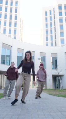 Enerjik dansçılar, modern mimari arkaplana karşı yeteneklerini ve coşkularını sergileyerek senkronize bir açık hava gösterisi gerçekleştiriyorlar.