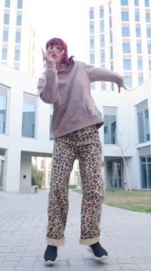 Yetenekli bayan dansçı, şehir mimari arka planına karşı dinamik, akışkan hip hop hareketleri sergiliyor, tutku ve enerjiyle çağdaş sokak dansı tarzını ifade ediyor.